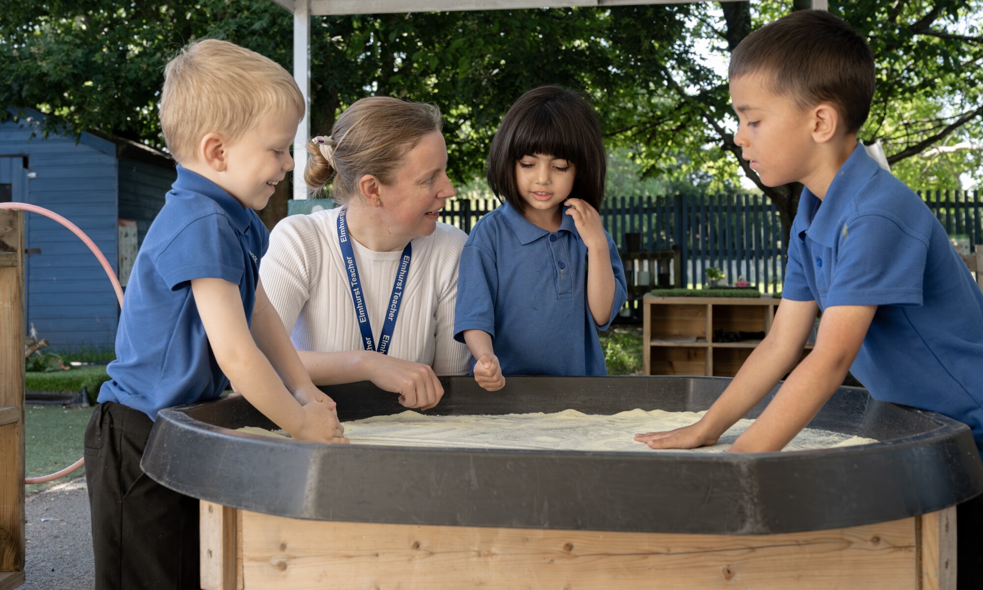 Elmhurst school children playing with sand under supervision